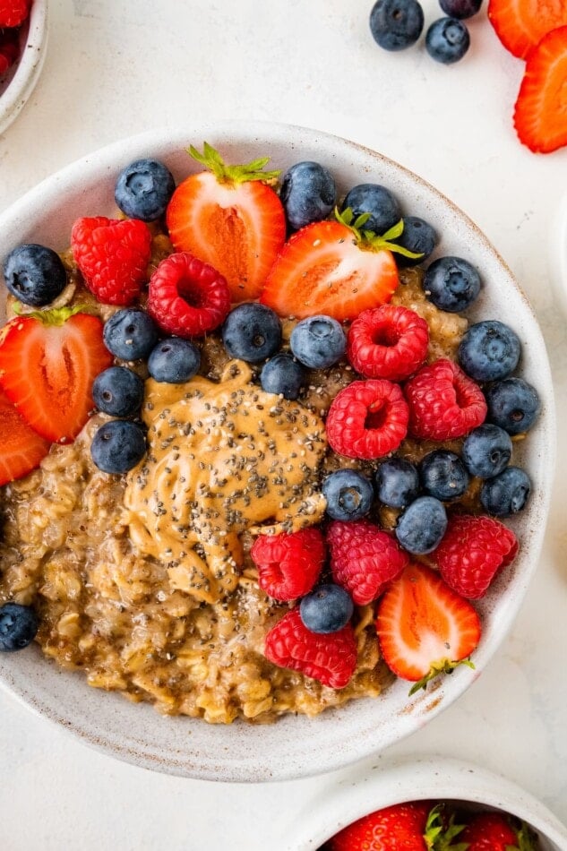 A bowl of cauliflower oatmeal topped with fresh mixed berries.