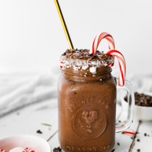 A chocolate peppermint smoothie next to a small candy dish with peppermints.