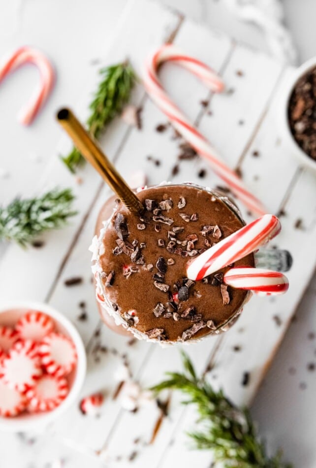 A chocolate peppermint smoothie topped with chocolate shavings and candy canes.