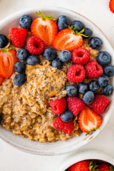 A bowl of cauliflower oatmeal topped with fresh mixed berries.