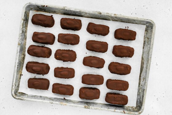 Homemade almond joy bars on a parchment lined baking sheet.