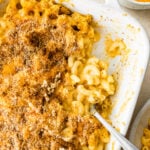 A baking dish containing healthy baked mac and cheese, some portions have been removed.