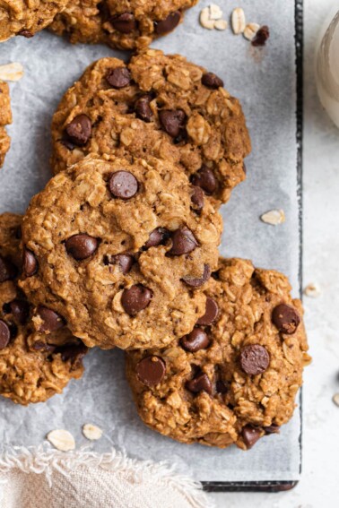 Overhead view of a few chocolate chip oatmeal cookies stacked around each other.