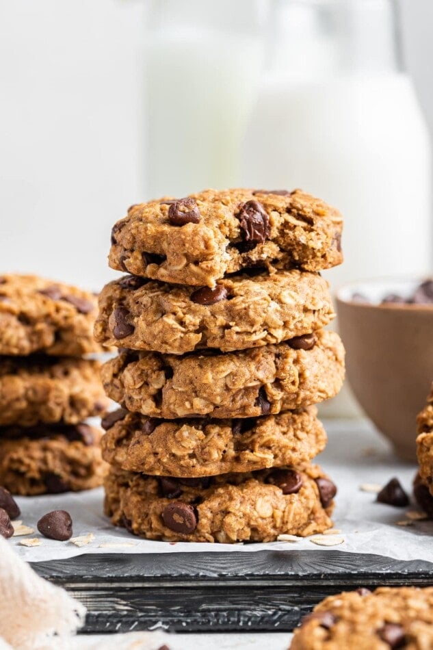 Five healthy chocolate chip oatmeal cookies stacked on top of each other, the top cookie has a bite taken out of it.