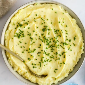 Healthy mashed potatoes in a bowl topped with chives.
