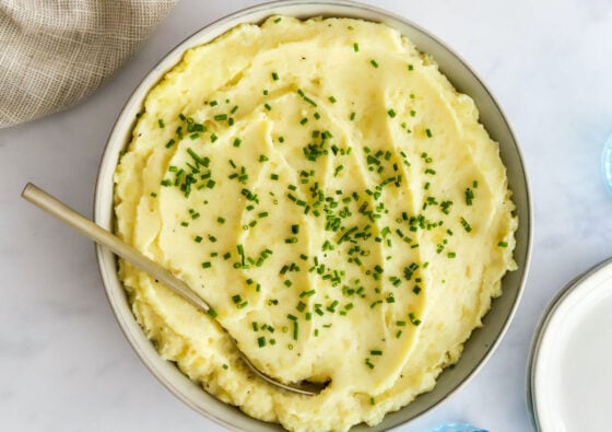 Healthy mashed potatoes in a bowl topped with chives.