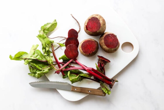 Preparing beets by removing the stems and ends.