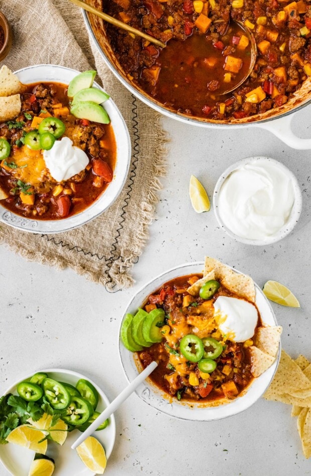 Two bowls of no bean chili next to a pot of the chili.