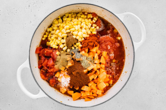 Sweet potato, corn, crushed tomatoes, diced tomatoes, broth, chili powder, smoked paprika, cumin, salt, oregano, pepper and cinnamon added to the pot.