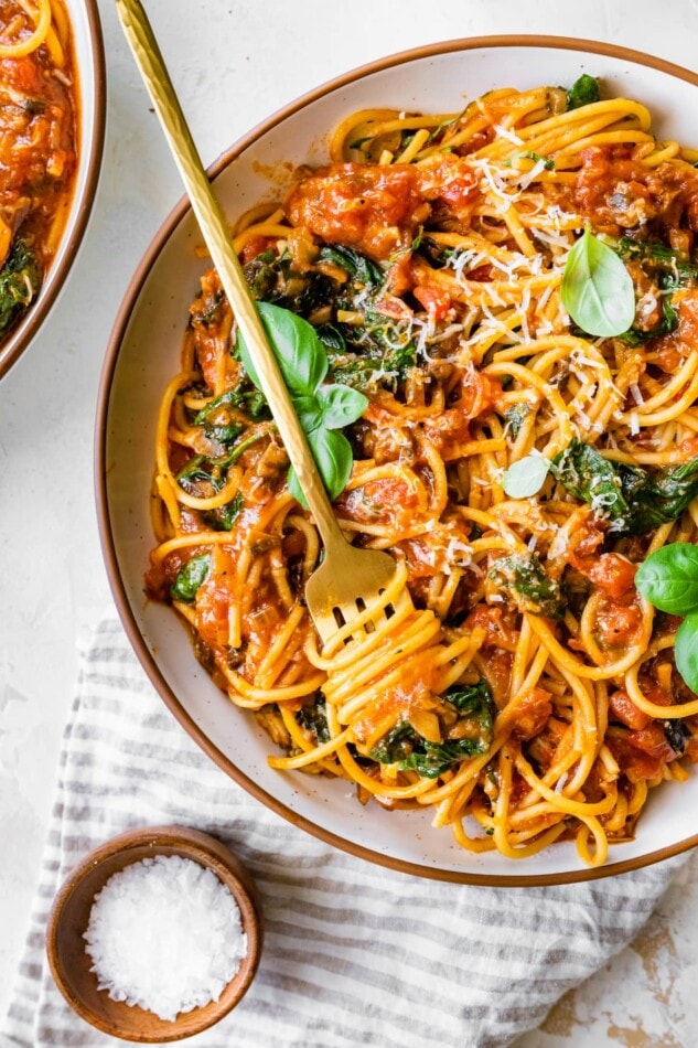 A bowl of pasta with a bite twirled onto a fork.