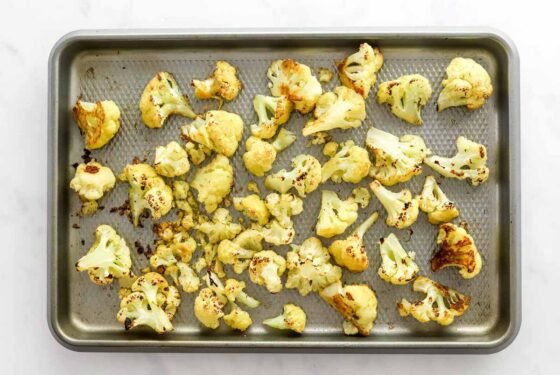Roasted cauliflower florets on a sheet pan.