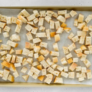 Sourdough cubes on a baking sheet lined with parchment paper.