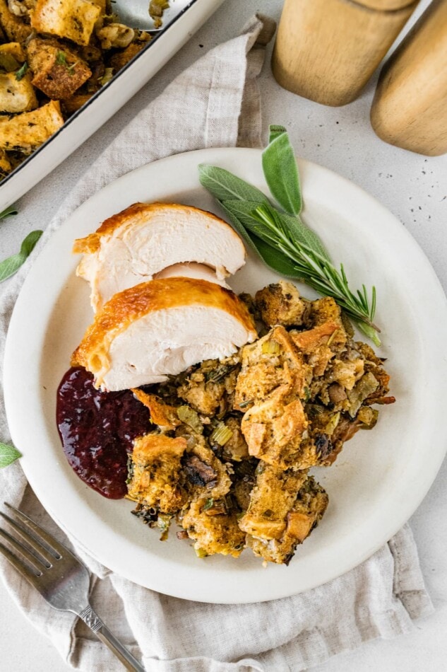 A serving of sourdough stuffing serve with turkey, cranberry and fresh sage.