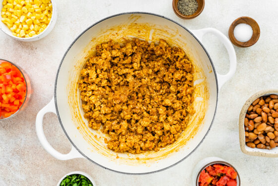 Cooked and seasoning ground turkey in a pot with garlic and onion.