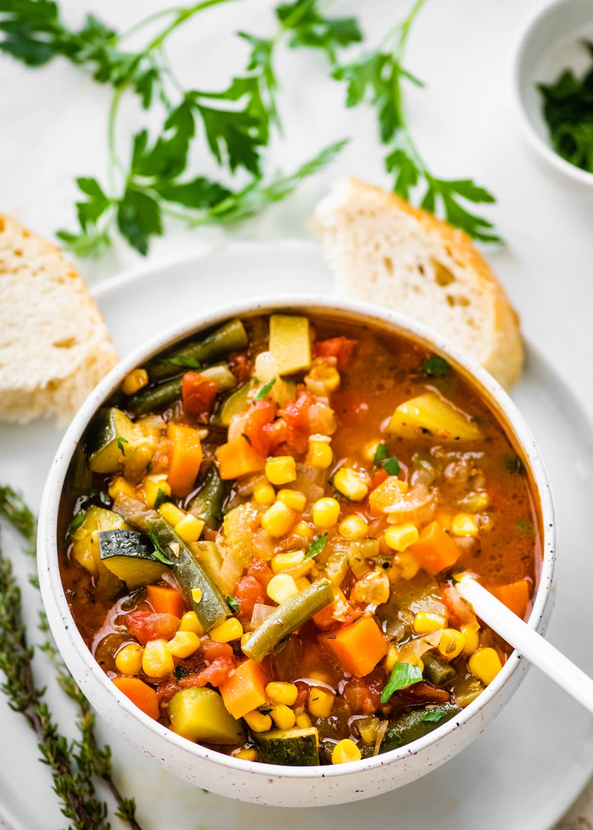 A bowl of vegetable soup served with crusty bread.