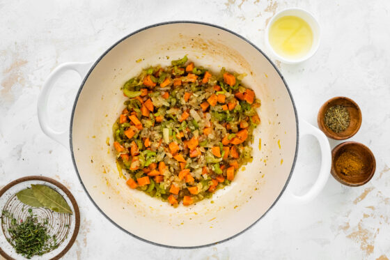 Carrots, celery, onion and garlic sautéing in a pot.