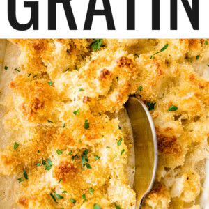 Cauliflower gratin in a baking dish with a serving spoon.