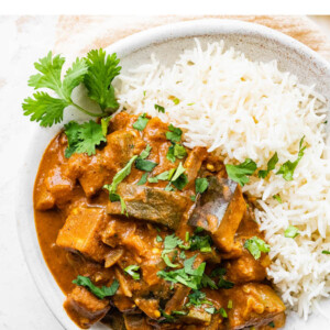 Eggplant curry plated with cilantro and rice.