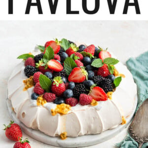 Pavlova topped with coconut whipped cream and fresh fruit.