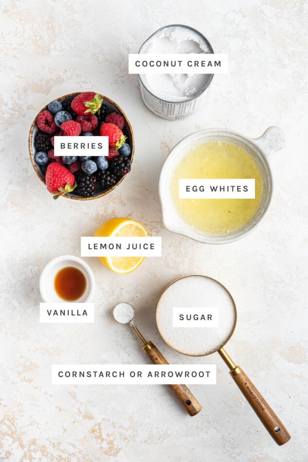 Ingredients measured out to make a Pavlova: coconut cream, berries, egg whites, lemon juice, vanilla, sugar and cornstarch/arrowroot.