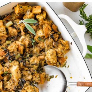 Sourdough stuffing in a serving dish with a serving spoon.