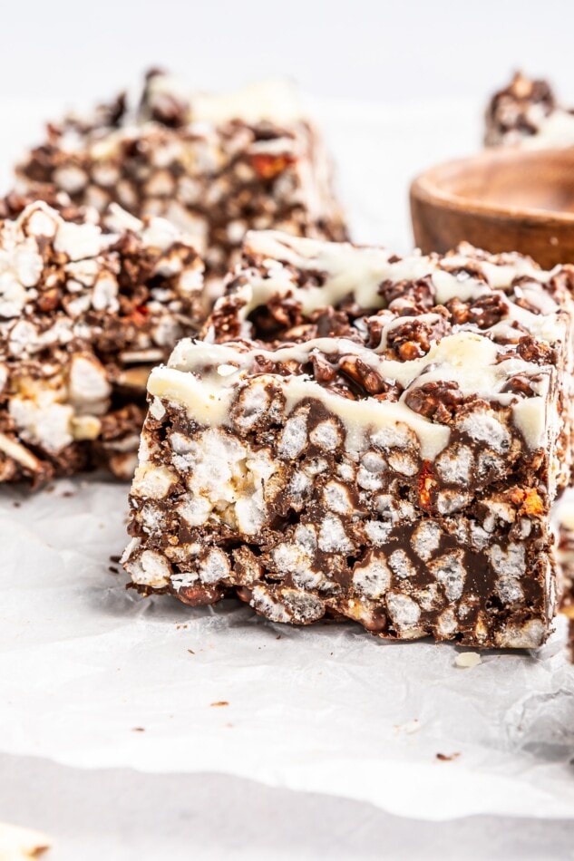 Two crispy chocolate rice cake bars on parchment paper.