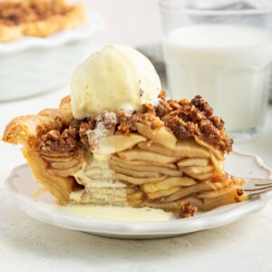 A slice of healthier dutch apple pie topped with vanilla ice cream.