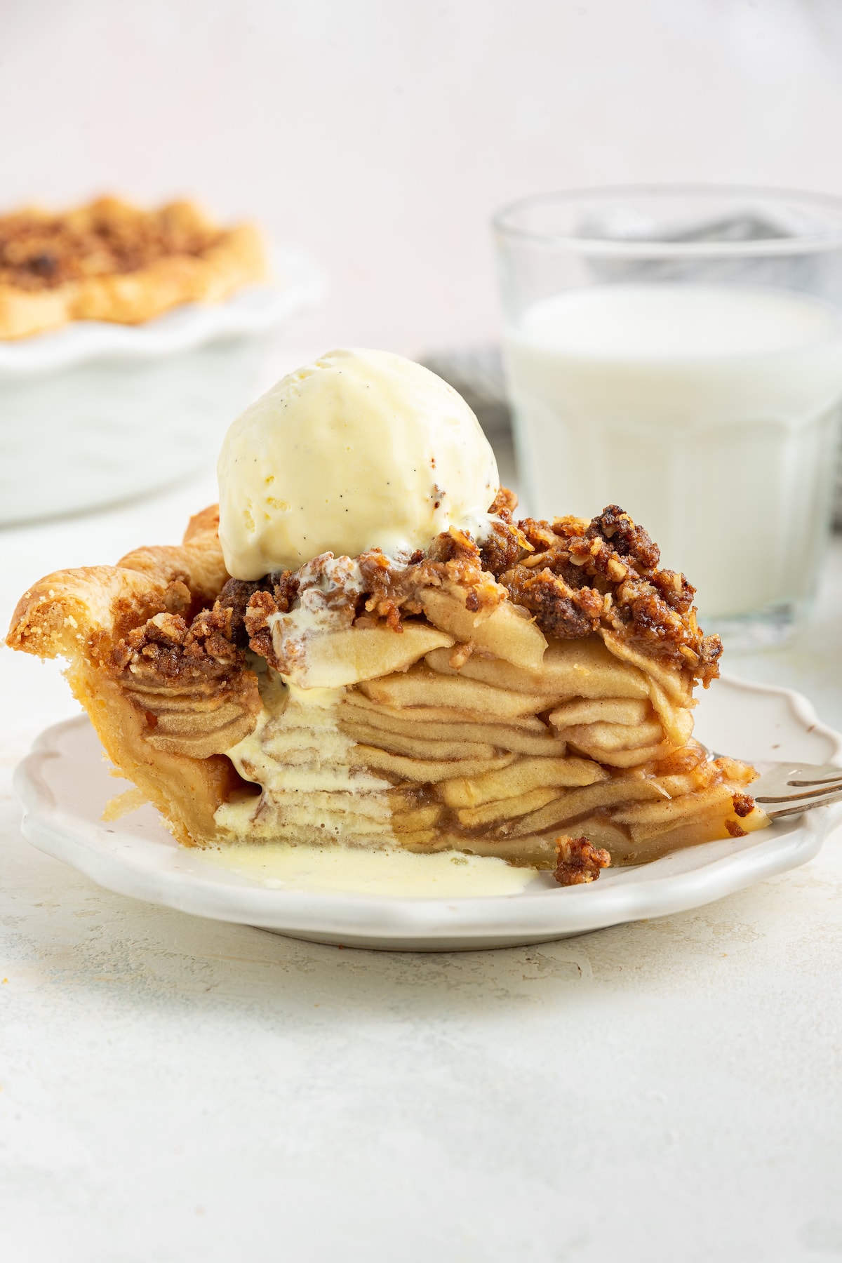 A slice of healthier dutch apple pie topped with vanilla ice cream.