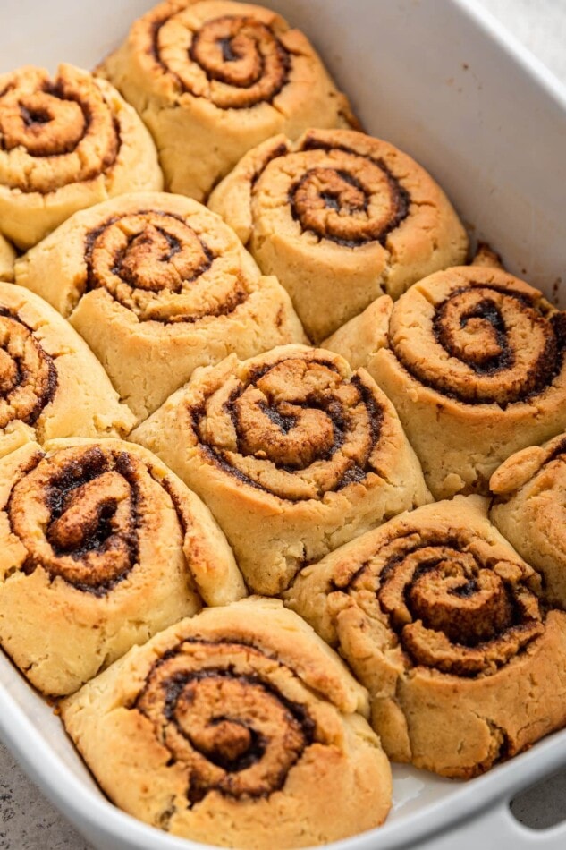 Unfrosted gluten-free cinnamon rolls in a baking dish.