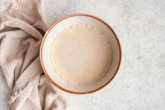 Yeast, sugar and warmed milk combined in a bowl.