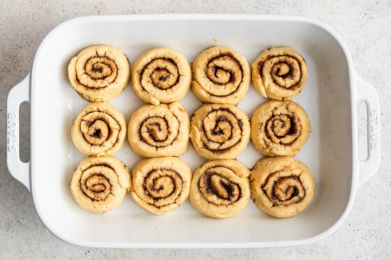 Cinnamon rolls placed 3 by 4 in a baking dish.