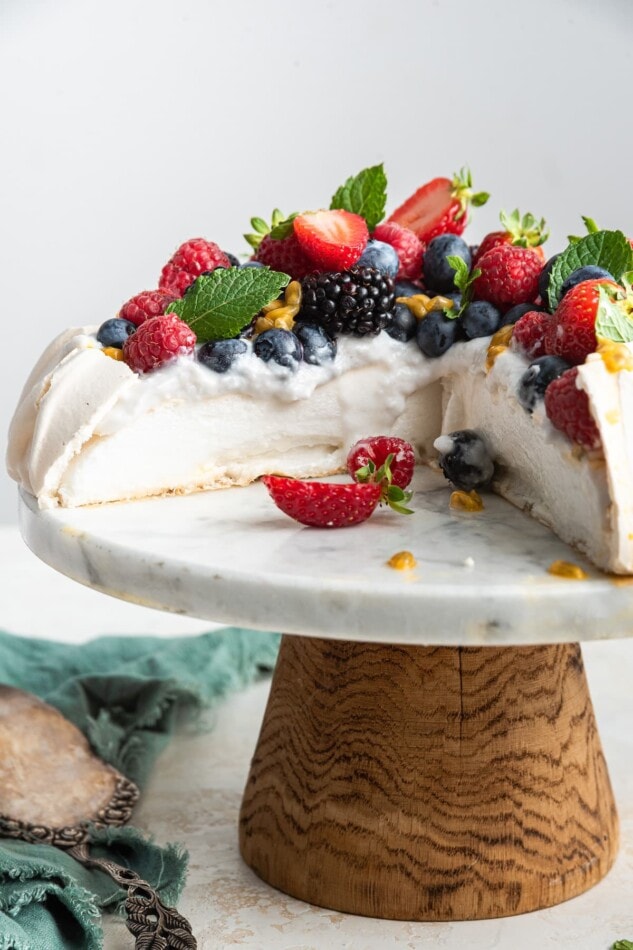 A sliced pavlova cake on a cake stand.