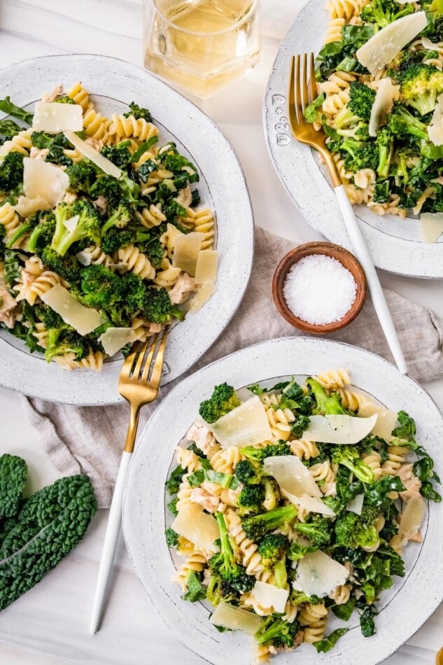 Three plates of tuna, broccoli and kale caesar pasta salad.