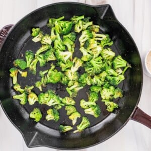 Cooked broccoli florets in a cast iron skillet.