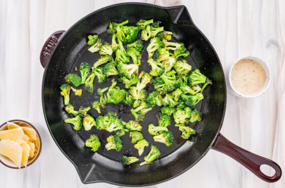 Cooked broccoli florets in a cast iron skillet.