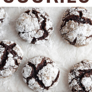 Chocolate crinkle cookies on parchment paper.