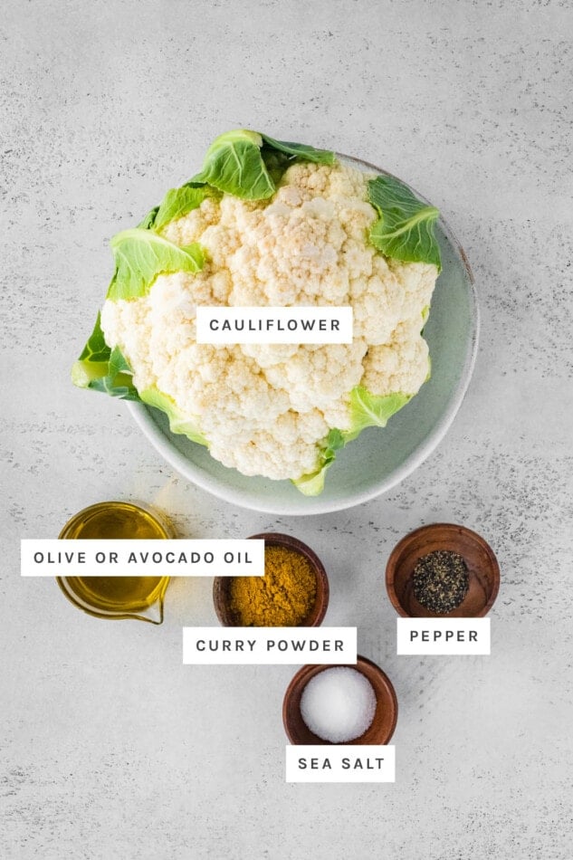 Ingredients measured out to make Curry Roasted Cauliflower: cauliflower, olive/avocado oil, curry powder, sea salt and pepper.