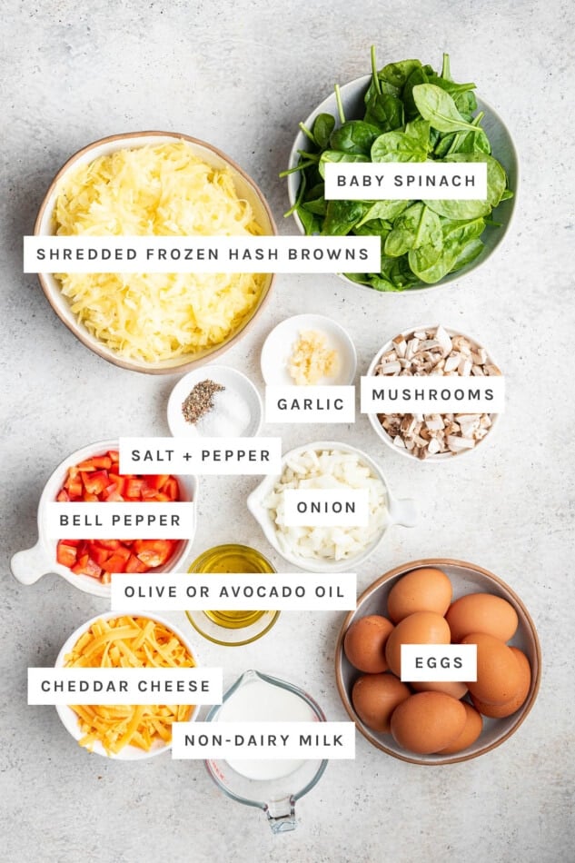 Ingredients measured out to make Vegetarian Hash Brown Breakfast Casserole: shredded frozen hash browns, baby spinach, garlic, mushrooms, salt, pepper, bell pepper, onion, olive or avocado oil, eggs, cheddar cheese and non-dairy milk.