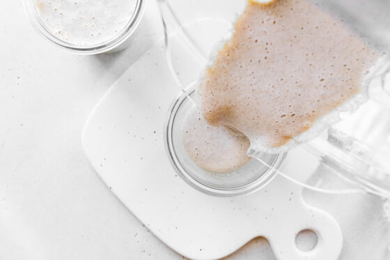 Pouring oats into a jar.