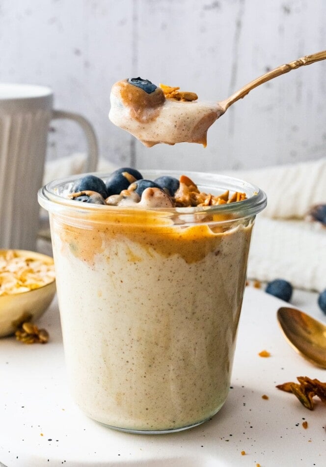 A spoonful of blended overnight oats over a jar.