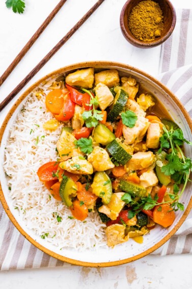 Chicken curry with vegetables served with rice.