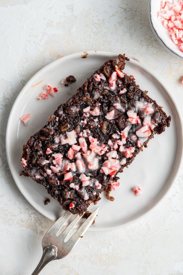 A slice of chocolate peppermint baked oatmeal on a plate with a fork.