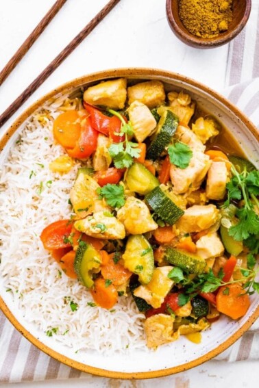 Chicken curry with vegetables served with rice.