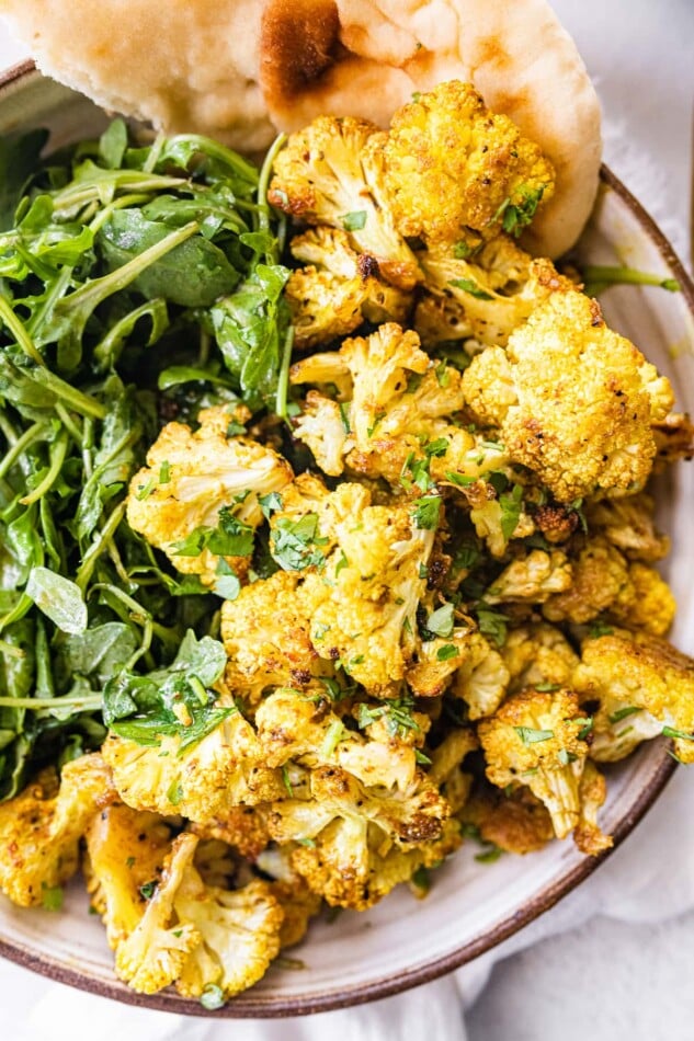 Curry roasted cauliflower served with greens.