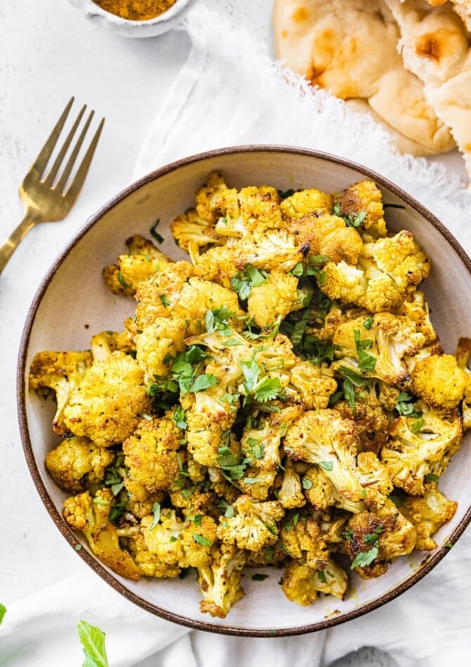 Curry roasted cauliflower florets in a bowl.