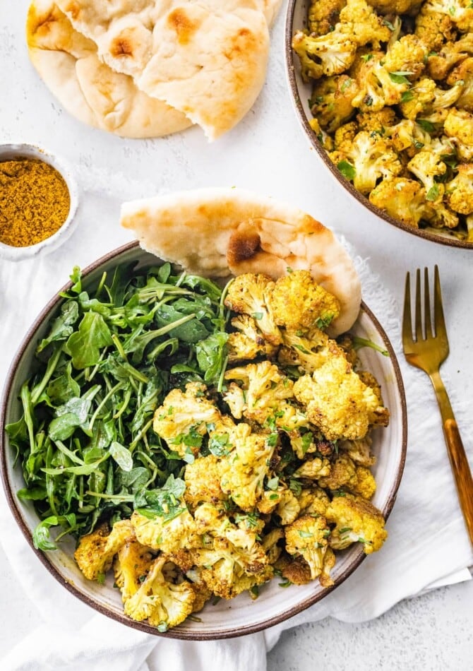 Curry roasted cauliflower served with greens and naan.