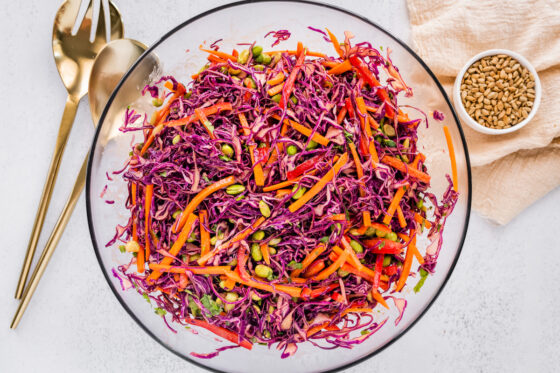 Vegetables and dressing tossed together in a bowl.