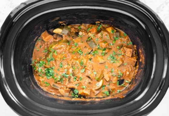 Fresh herbs added to eggplant curry in slow cooker.