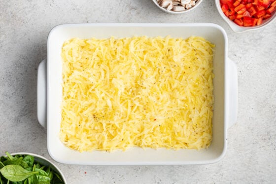 Shredded potatoes lining the bottom of a baking dish.