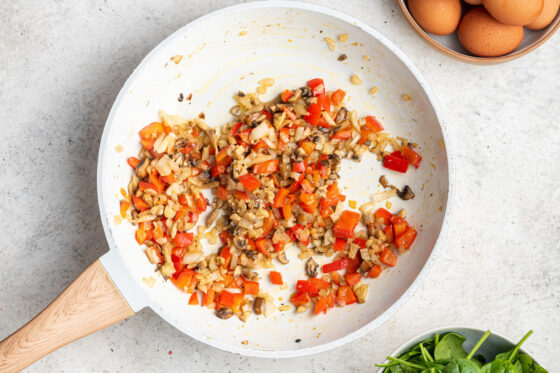 Veggies cooking in a sauté pan.